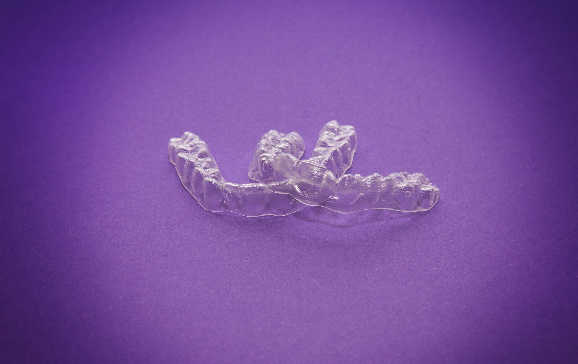 Isolated transparent teeth prosthesis over purple for design